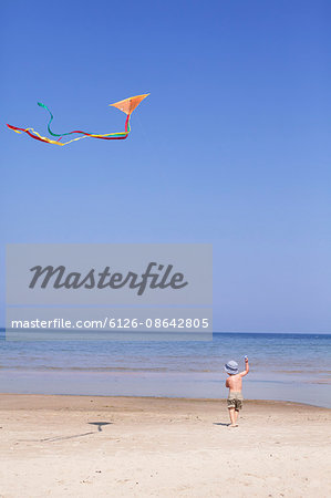 Sweden, Gotland, Faro, Skar, Boy (2-3) flying kite on beach