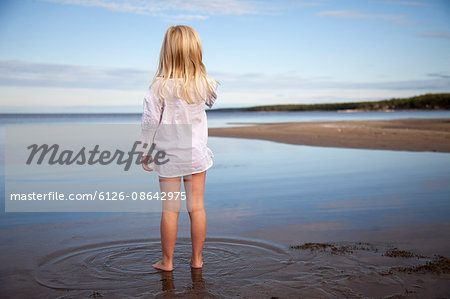 Sweden, Medelpad, Juniskarr, Blonde girl (6-7) standing in water
