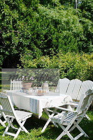 Sweden, Gotland, Bursvik, Burgegard, White table and chairs in garden