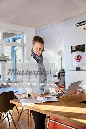 Sweden, Mature woman working at home