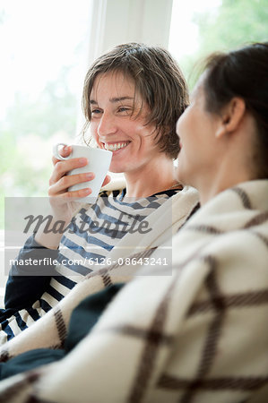 Two women having coffee in living room