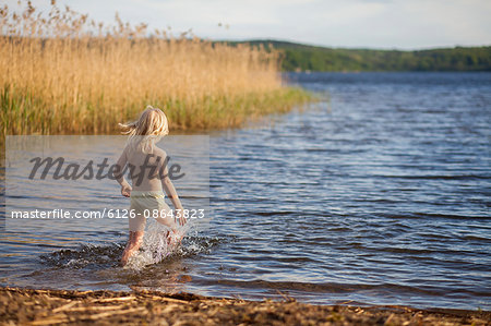 Sweden, Vastergotland, Lerum, Lake Aspen, Girl (6-7) running into water