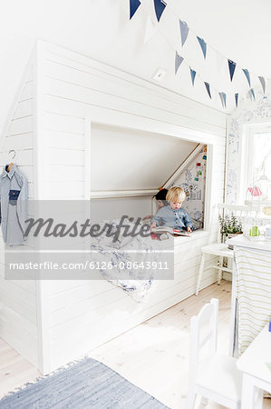 Sweden, Boy and girl (2-3) reading books in bedroom