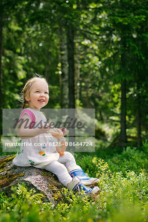 Finland, Paijat-Hame, Girl (2-3) playing with doll in forest