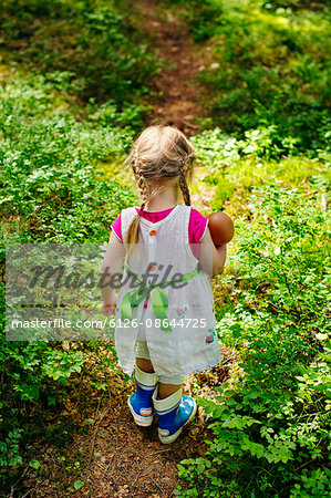 Finland, Paijat-Hame, Rear view of girl (2-3) with doll on footpath in forest