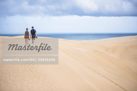 Two tourists at Te Paki Sand Dunes on 90 Mile Beach, Northland, New Zealand, Pacific