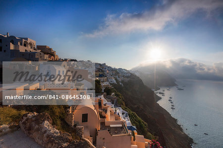 Sunbeam through the clouds over the Aegean Sea seen from the typical village of Oia, Santorini, Cyclades, Greek Islands, Greece, Europe