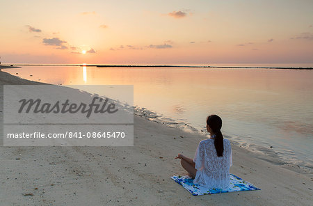 Woman practising yoga at sunrise, Rasdhoo Island, Northern Ari Atoll, Maldives, Indian Ocean, Asia