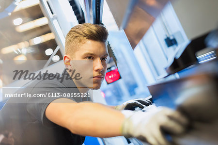 Worker operating machinery in steel factory