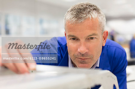 Close up of worker examining piece in steel factory Close up of worker examining piece in steel factory