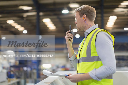 Supervisor using walkie-talkie in steel factory