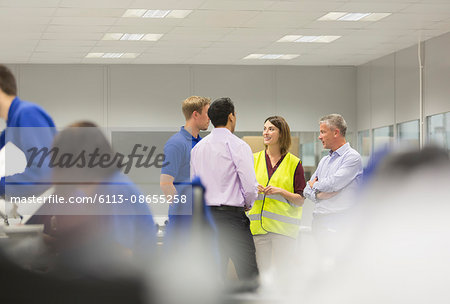 Managers and workers talking in steel factory