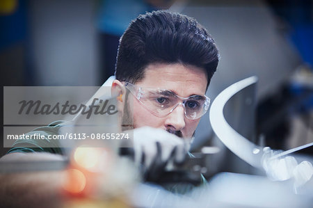 Worker examining pieces in steel factory Worker examining pieces in steel factory