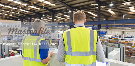 Supervisors on platform above steel factory