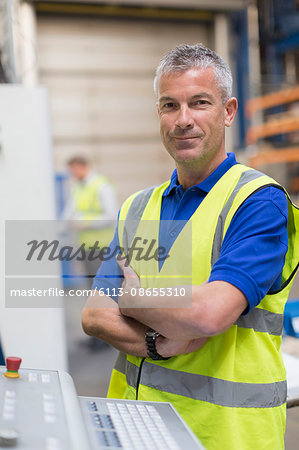 Portrait confident worker at control panel in steel factory Portrait confident worker at control panel in steel factory