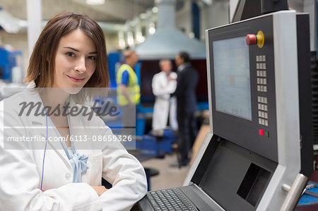 Portrait smiling female engineer at control panel in steel factory