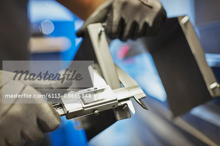 Worker measuring steel with calipers in steel factory Worker measuring steel with calipers in steel factory
