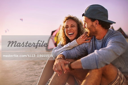 Laughing couple sitting on beach