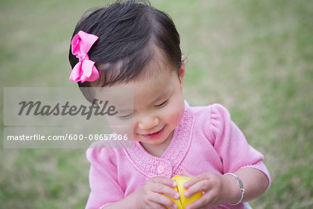Toddler Girl Smiling while she Opens an Easter Egg