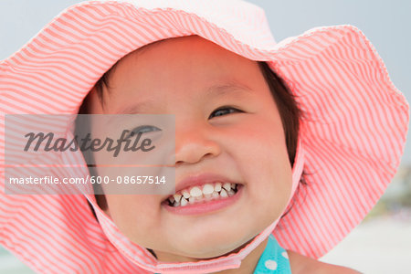 Close-up Portrait of Toddler Girl wearing Sunhat and Smiling at Beach, Destin, Florida, USA