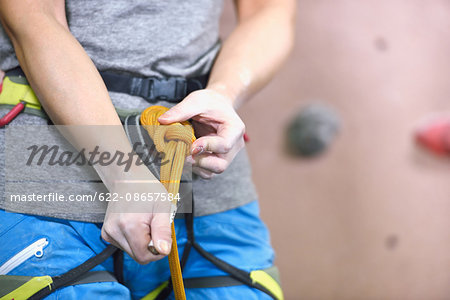 Japanese climbing athlete getting ready to climb gym wall