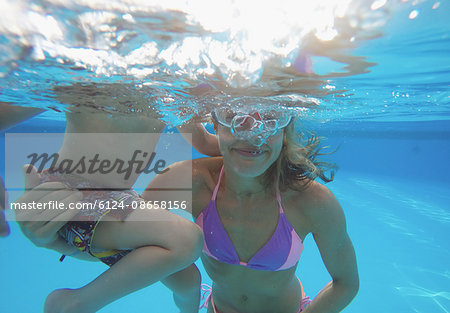 Mother and son swimming underwater in swimming pool