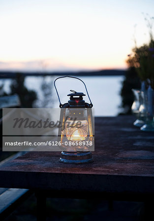 Sweden, Stockholm, Dalaro, Lantern on table at dusk