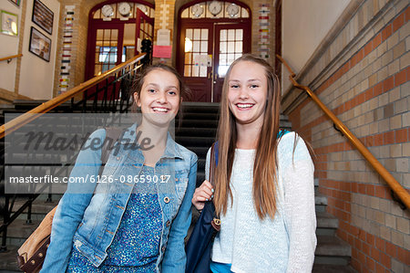 Portrait of two girls (14-15) in school building