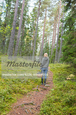 Sweden, Ostergotland, Finspang, Mature woman exploring forest