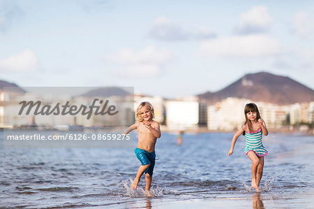 Spain, Gran Canaria, Las Palmas, Children (4-5) running on beach