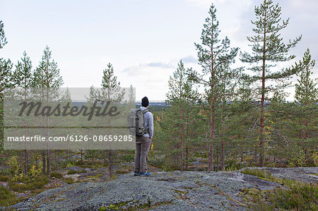 Sweden, Vasterbotten, Umea, Man standing on rocks looking at view