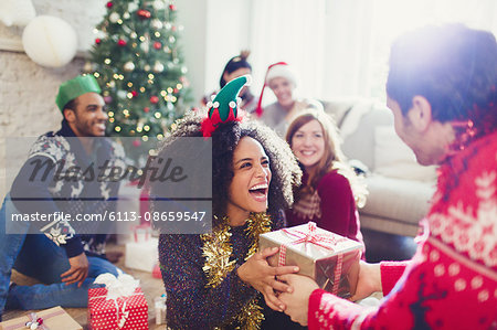 Enthusiastic friends exchanging Christmas gifts