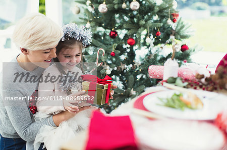 Smiling mother and daughter with Christmas gift