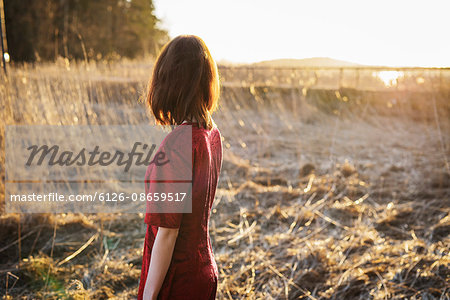 Finland, Varsinais-Suomi, Young woman standing in field