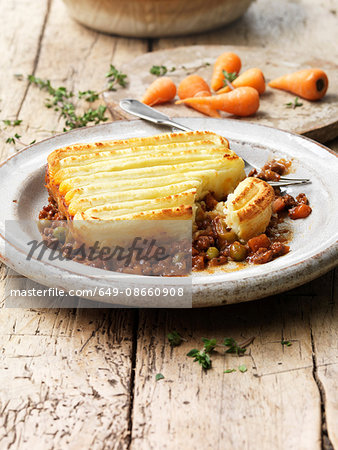 Food, traditional meals, cottage pie on vintage plate, minced beef, peas, carrots, onions, mashed potato, gravy, rustic wooden table