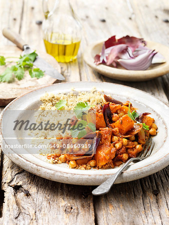 Food, vegetarian meals, roasted butternut squash with red onion, chick peas, cous cous, coriander, olive oil, rustic wooden table