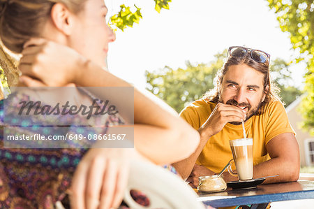 Young couple drinking coffee at sidewalk cafe, Franschhoek, South Africa