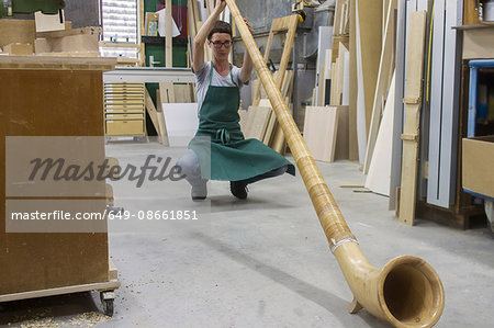 Woman in workshop checking alphorn