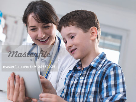 Doctor and boy using digital tablet