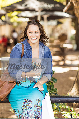 Woman holding ice cream cone looking at camera smiling