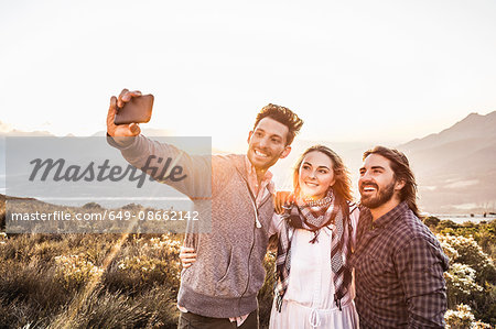 Friends on hillside taking selfie