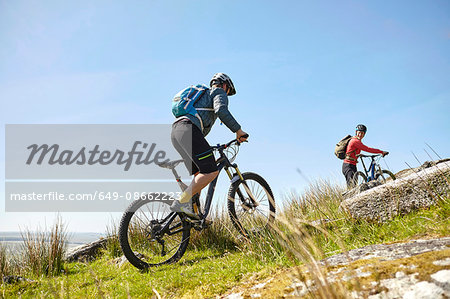 Cyclists cycling up hillside