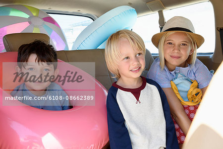 Happy children in car with beach gears for vacation