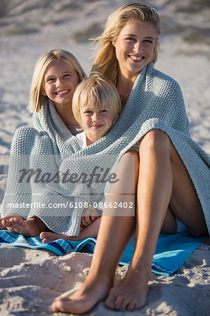 Portrait of a young woman enjoying on the beach with her children