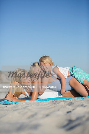 Children enjoying on the beach with their mother