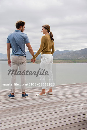 Young couple smiling at each other at lakeshore