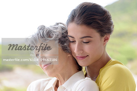 Loving young woman hugging her mother outdoors