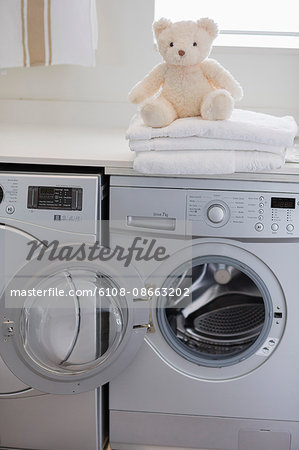Teddy bear on washing machine at home