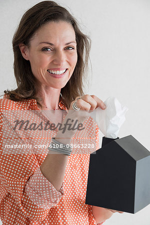 Happy woman taking out tissue paper from a box