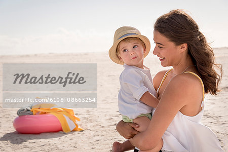 Happy mother with her little son enjoying on beach